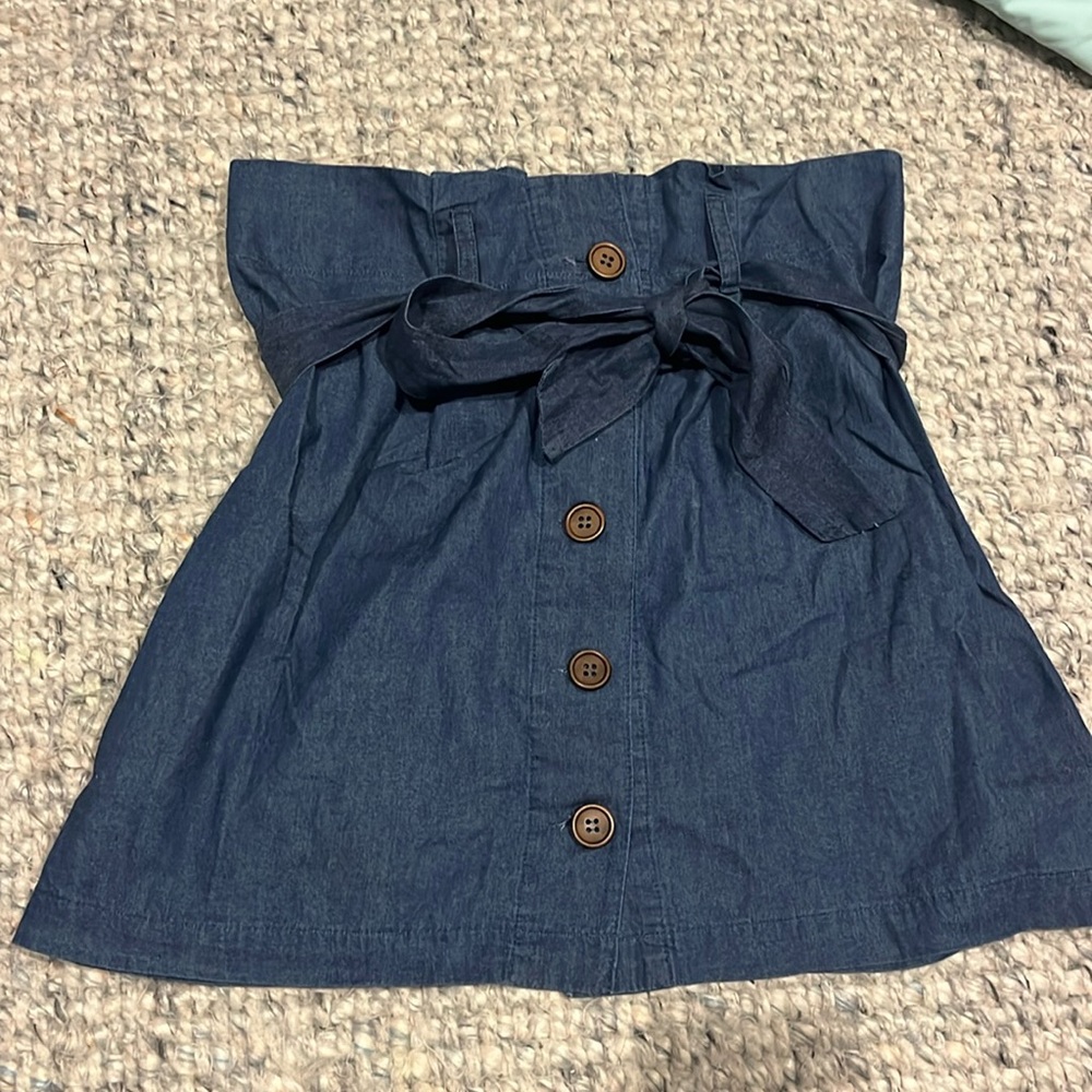 Denim miniskirt with buttons and waist tie.